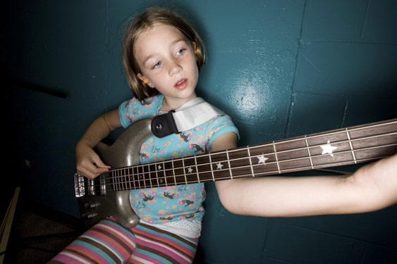 Girl tuning bass guitar