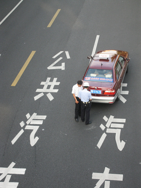 A taxi driver being ticketed in Shanghai