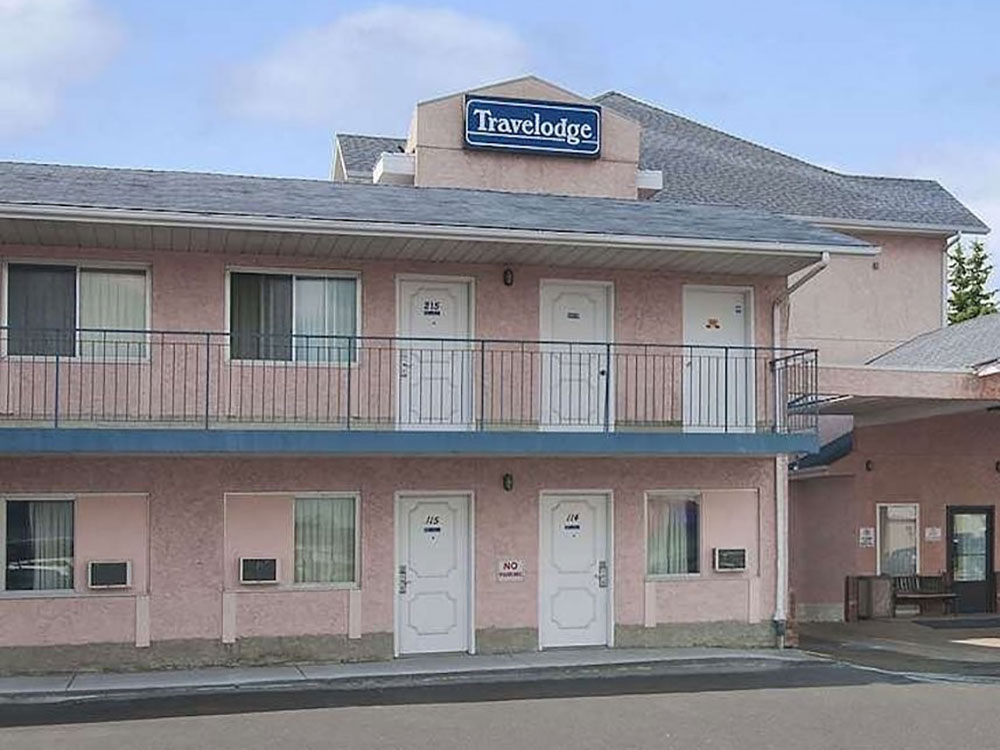 A two-floor Travelodge motel, painted pink with blue highlights.