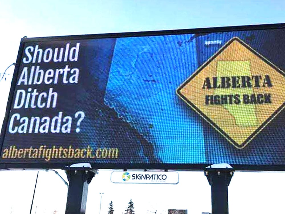 A billboard says 'Should Alberta Ditch Canada?' with a yellow sign that says 'ALBERTA FIGHTS BACK.'