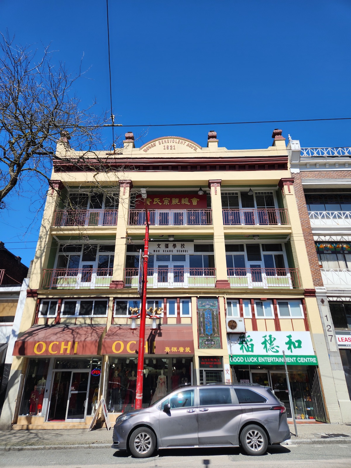 The exterior of the Wongs’ Benevolent Association building in Vancouver’s Chinatown on a sunny day. It is a three-storey building with beige trim.