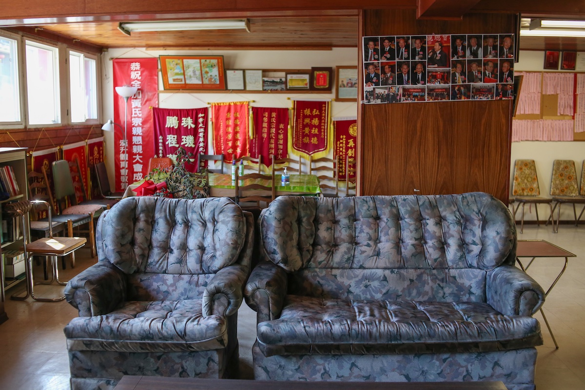 A matching ottoman and sofa set in a soft blue floral pattern sits in the lounge of the Wongs’ Benevolent Association building, a modest space with wood panelling and walls hung with red banners and photos of its members.