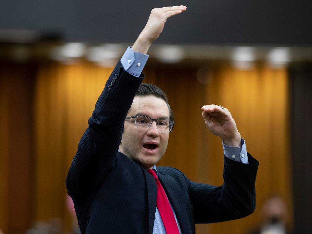An image of suit-clad Pierre Poilievre speaking and gesticulating. 