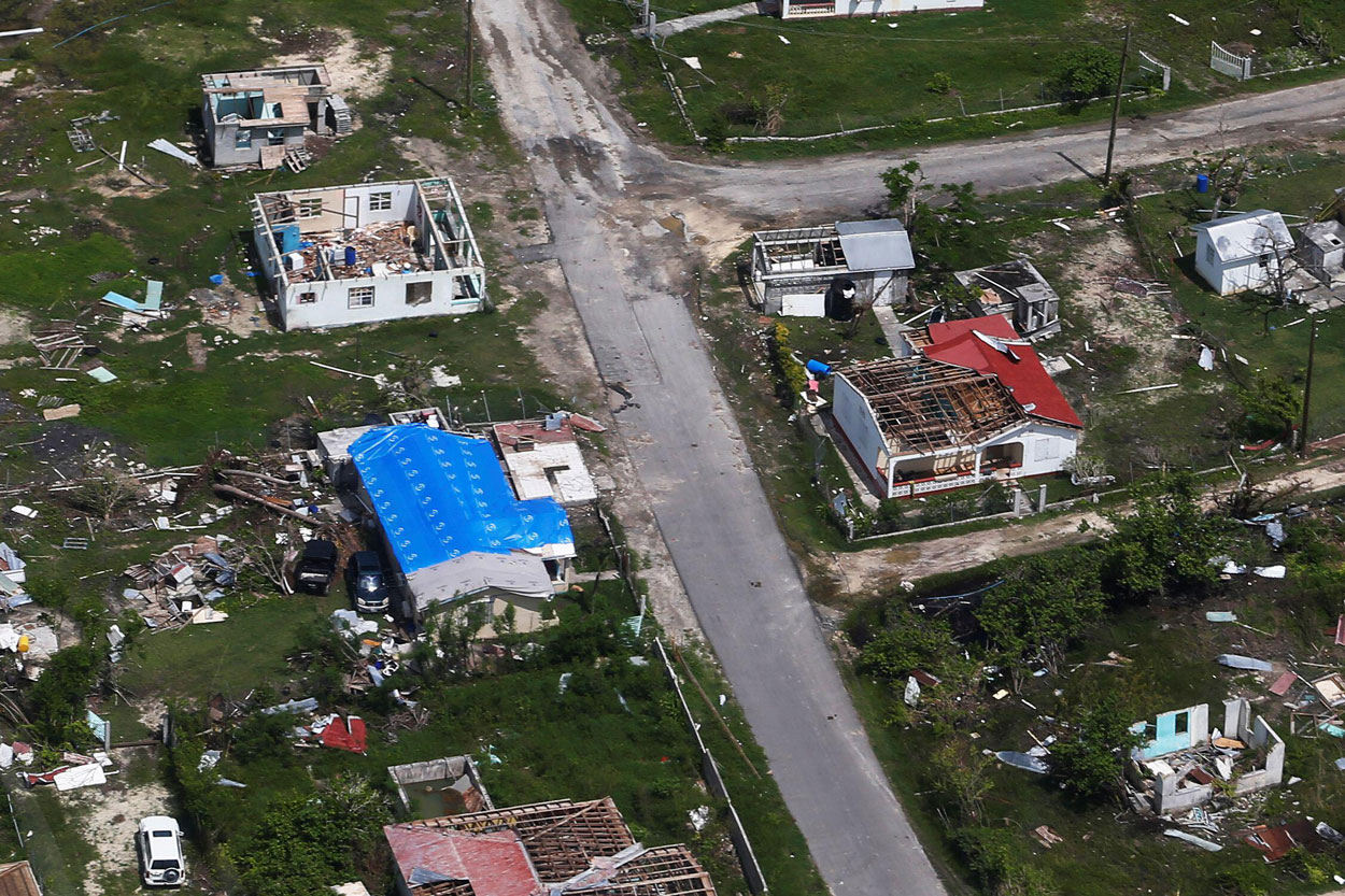 Overhead view of destroyed houses with roofs ripped off.