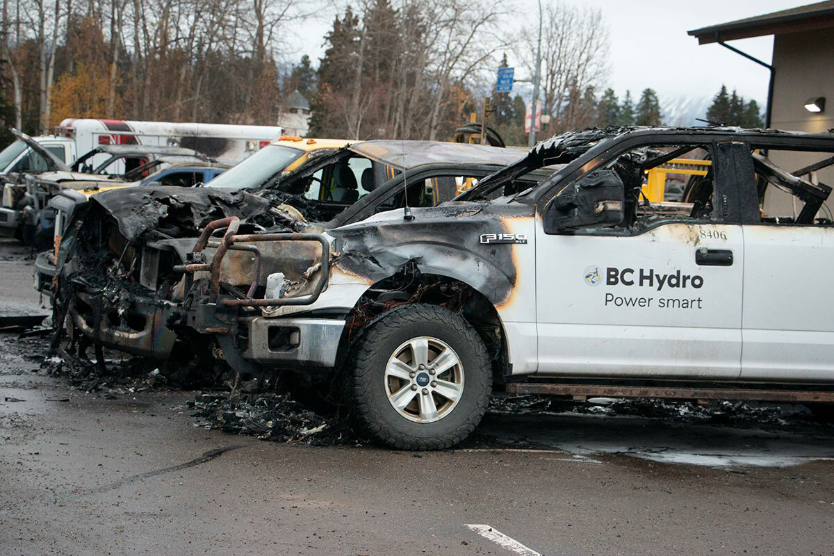 A row of burnt-out RCMP and other vehicles in a parking lot.