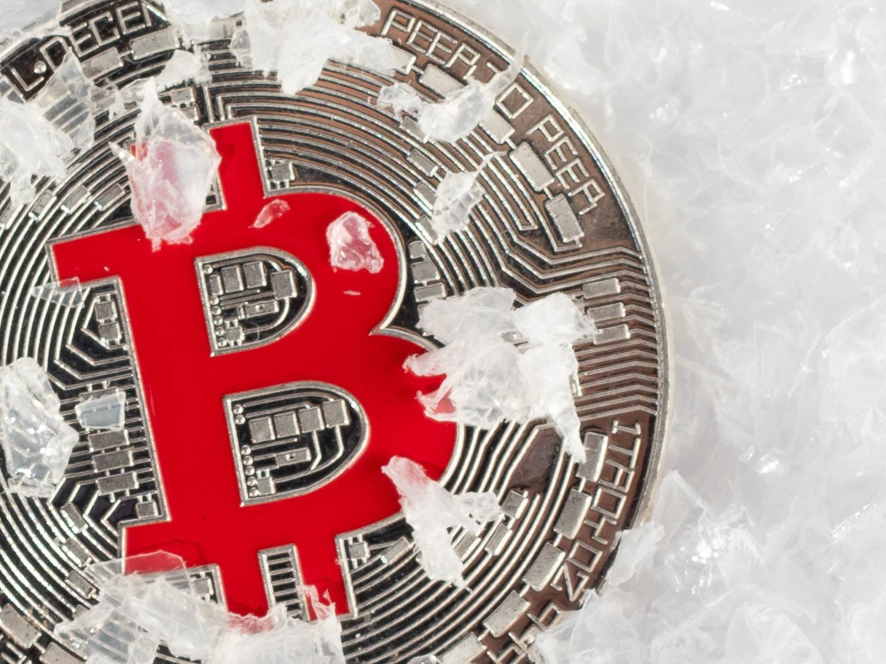 A bitcoin rests in snow. 
