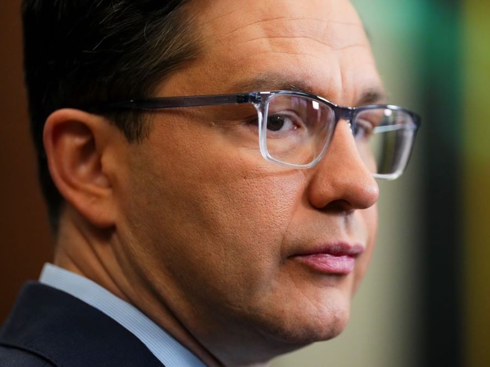 Close up profile photo of Pierre Poilievre who has dark hair and wears glasses.