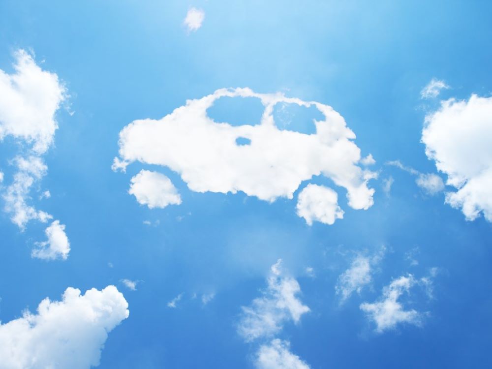 A car-shaped cloud floats among other clouds in a blue sky.