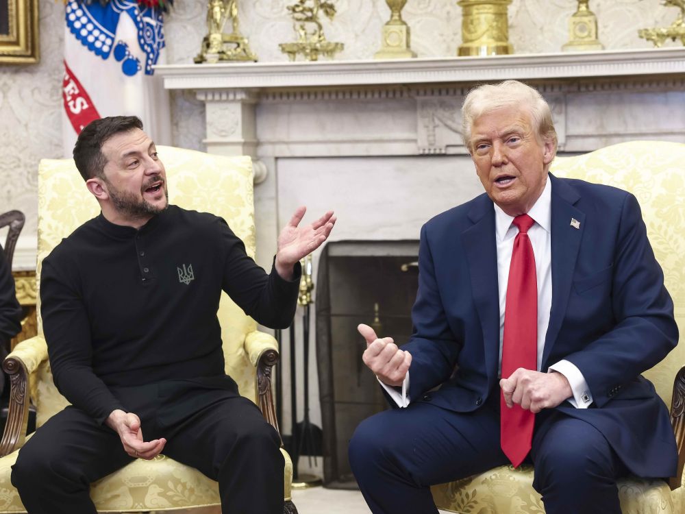 Volodymyr Zelenskyy, a bearded man dressed in black, gestures as Donald Trump leans forward to speak.