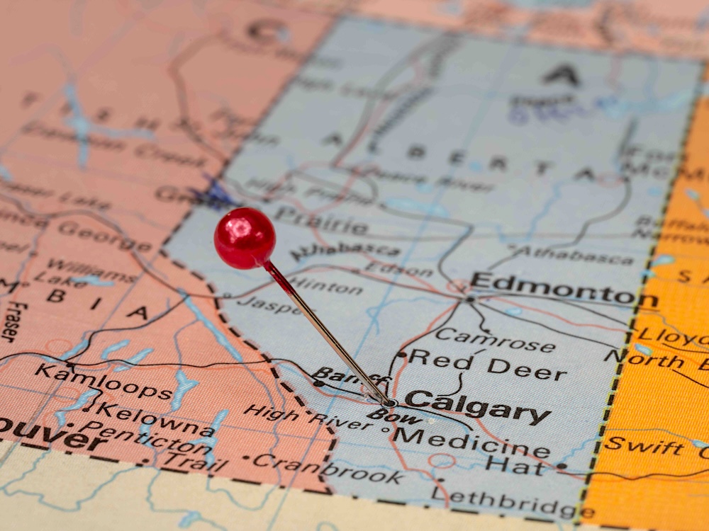 A red pin marks the city of Calgary on a map of Alberta, marked in blue.