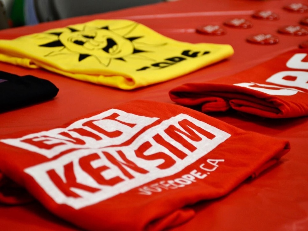 A folded tee-shirt with the lettering &lsquo;Evict Ken Sim&rsquo;.