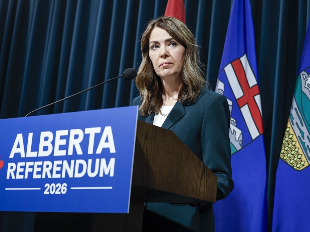 Danielle Smith, a woman with light skin and wavy brown hair with highlights, stands at a lectern that reads &lsquo;Alberta referendum 2026.&rsquo;