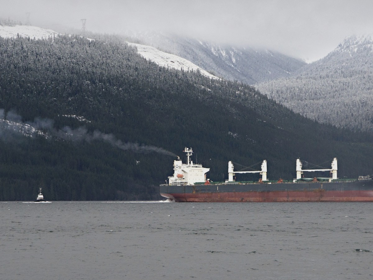 A massive tanker surrounded by snowy mountains.