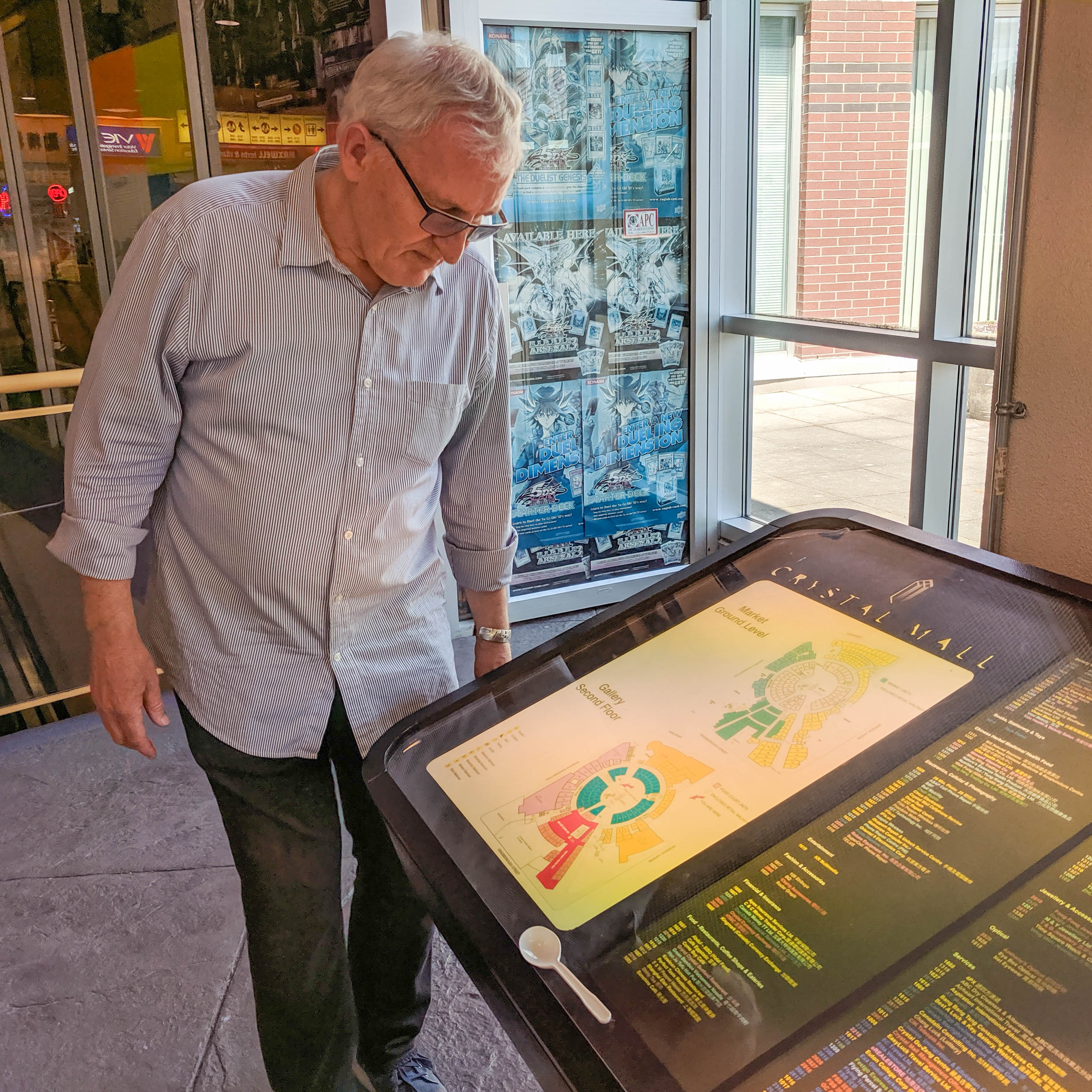 An older white man with white hair tilts his head down to consult the Crystal’s parking map.