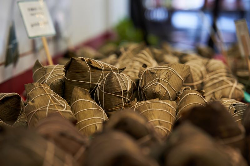 Green bundles of zongzi (also known as sticky rice dumplings) are arranged in baskets and ready for sale at Kam Wai Dim Sum in Vancouver’s Chinatown. The bundles are wrapped in green bamboo leaves and white butcher’s twine.