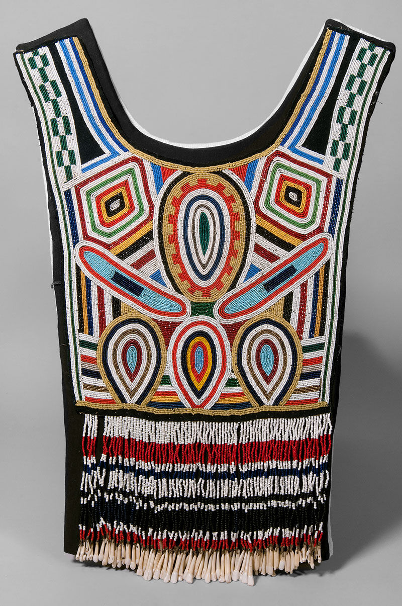 A colourful article of clothing features geometric patterns in the chest and tassels at the belly in rich hues of black, red, yellow, green and blue.