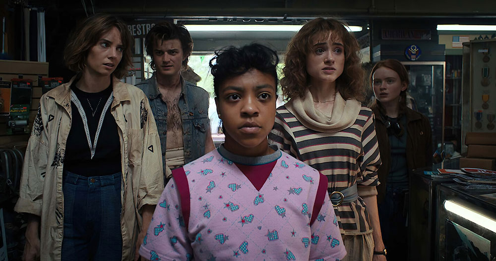Five people stand in a shop. A few of them look concerned. 