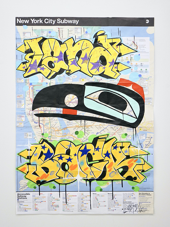 Colourful acrylic paint over a map of the New York City subway features yellow graffiti tags on the top and bottom of the frame, and an Indigenous painting of a raven using black paint in the centre.