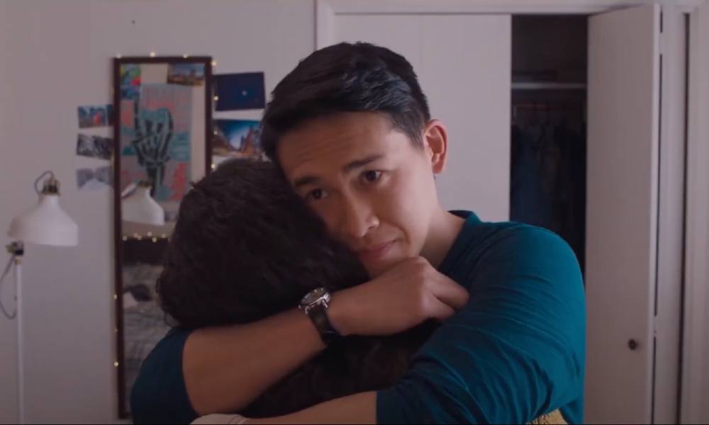 Jake Wong, pictured here and facing the camera, hugs his high school girlfriend in the coming-of-age dramedy <em>Golden Delicious<em>.