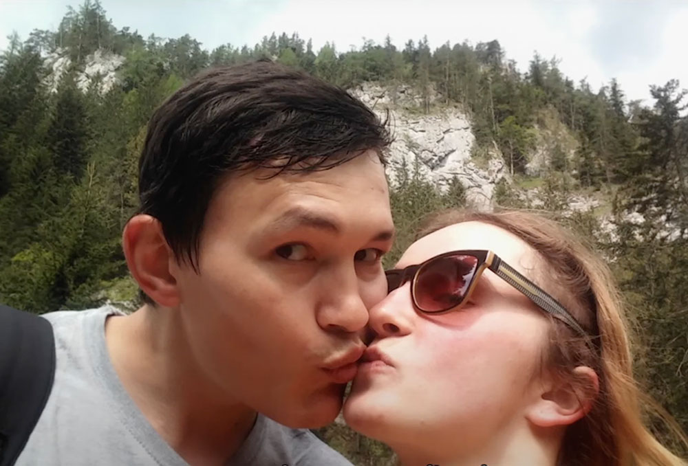 A selfie depicts a young couple standing outdoors. Martina Kušnírová, right, is kissing her fiancée Ján Kuciak, left, on the cheek as Kuciak looks at the camera.
