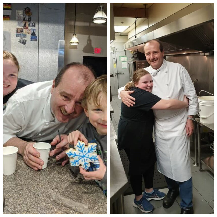  In the top photo Ralf Dauns poses between two kids at the counter of the Soup Meister. A young boy with blonde hair and a grey shirt holds a snowflake sugar cookie on the right. Dauns is in the middle; an older girl with blonde hair is on the left, smiling. In the bottom photo, Ralf Dauns poses with a young girl who is hugging him around the waist. They are standing in the kitchen of the Soup Meister.