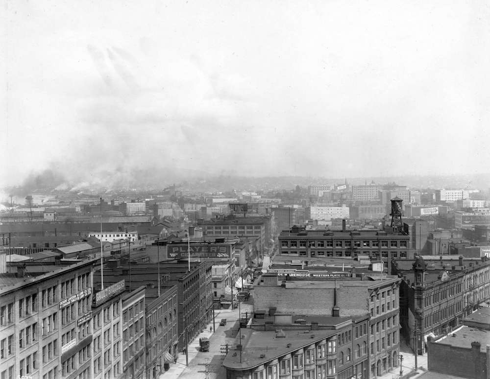 A black and white aerial photo of Water Street shows old buildings, and paved streets.