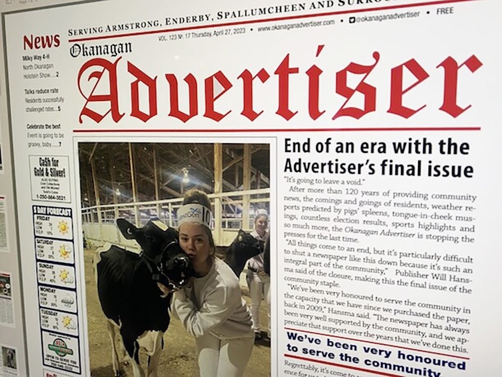 The digital cover of the Okanagan Adviser newspaper shows text surrounding a photo of a young woman smiling with a cow.