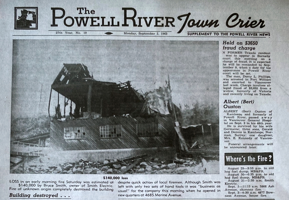 In an above-the-fold photo, the burnt-out husk of what appears to have been a wooden building is partially collapsed.