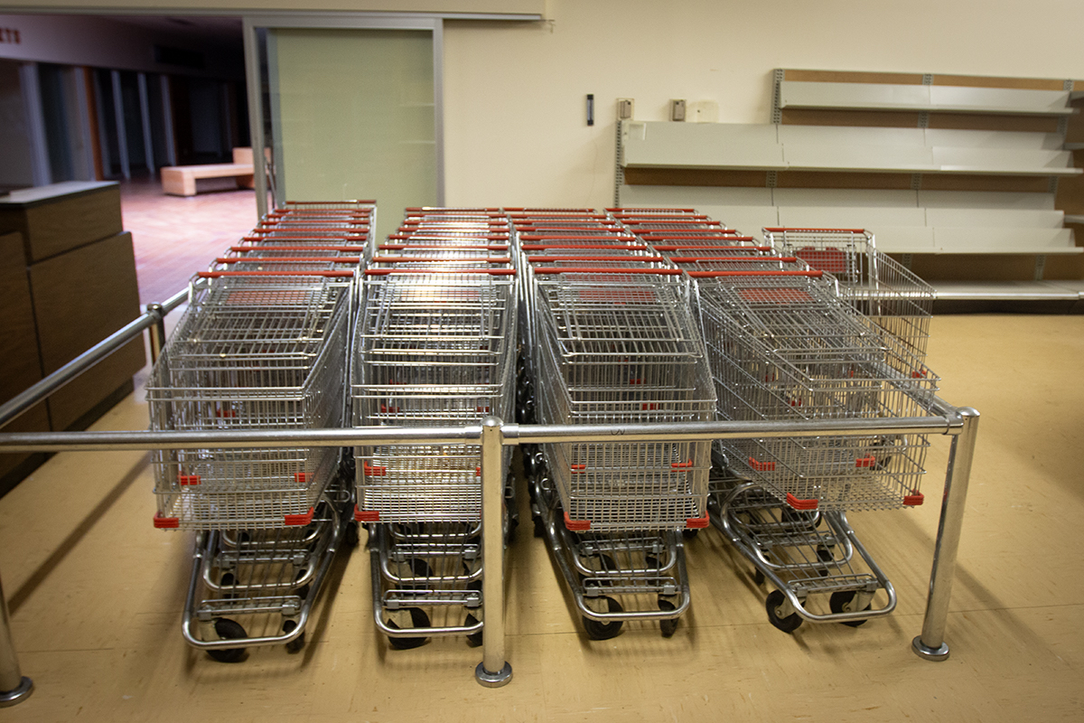Shopping carts are neatly stacked together in an empty grocery store.