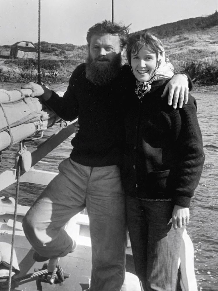 In a black and white photograph, Farley and Claire Mowat pose on a sailboat.