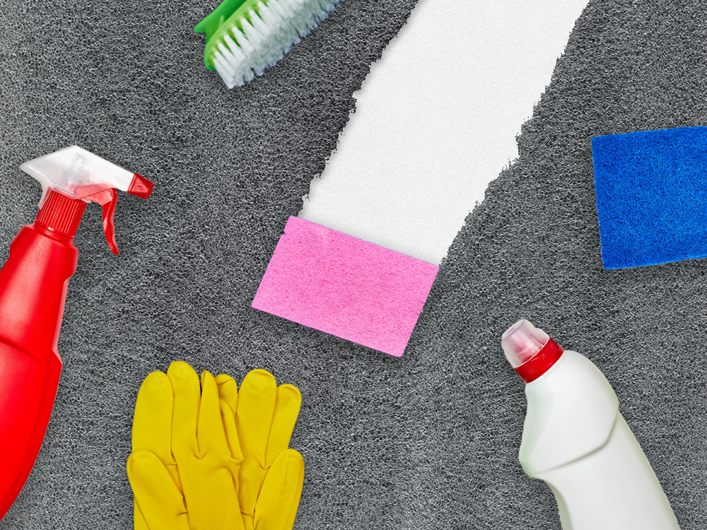A photo collage of cleaning products across a grey textured surface. In the centre of the frame, a bright pink sponge traces a thick line that reveals a clean white surface beneath the textured grey across the frame.
