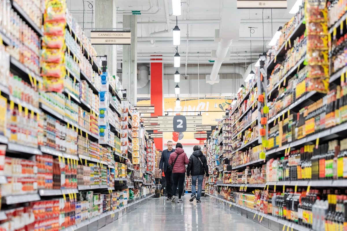 A supermarket aisle with full shelves.