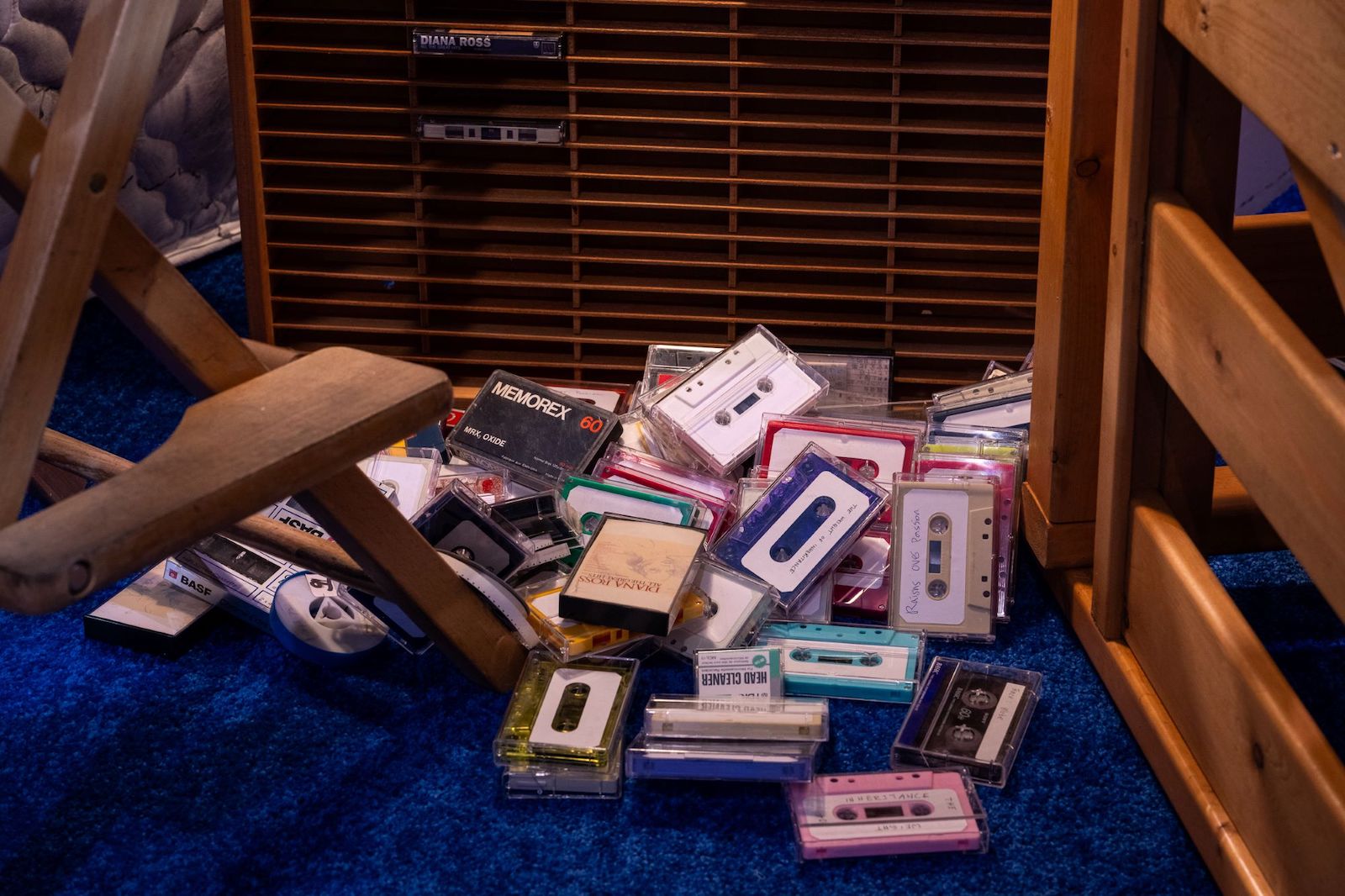 A pile of random cassette tapes on a blue shag carpet.