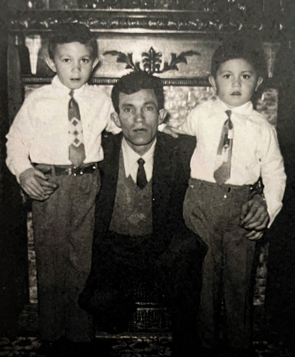 An old black and white photo. Alain Raoul, centre, in a suit, flanked by two young boys.