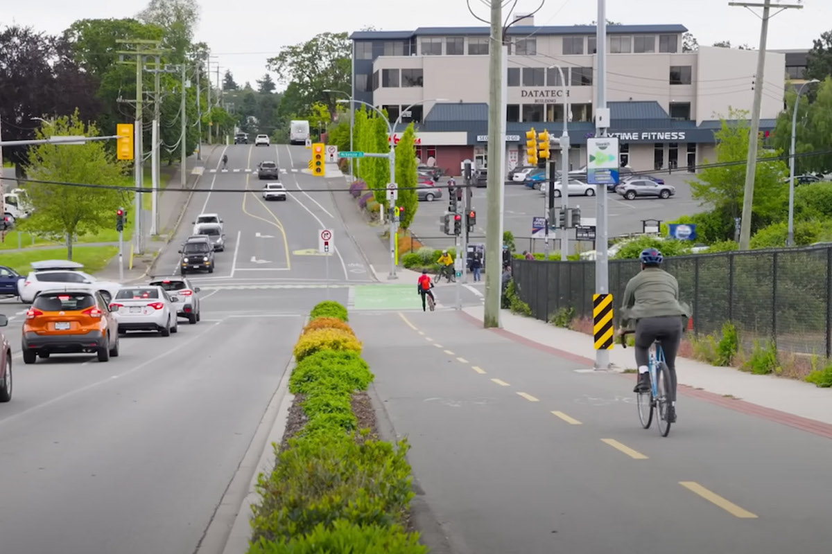 Unimpeded by vehicles, a couple of cyclists make their way down a protected cycling lane in Saanich.