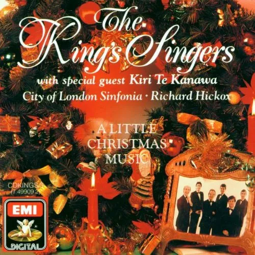 The album cover art for the King&rsquo;s Singers&rsquo; A Little Christmas Music features fanciful white text over a red yuletide scene featuring a wreath and a framed photos of the King&rsquo;s Singers in black-tie formalwear.