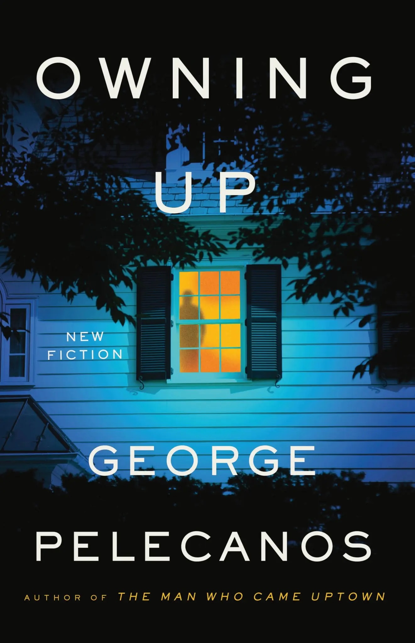 The book cover image for George Pelecanos’ Owning Up features a view of a home with white stucco siding at dusk, cast in blue. The silhouette of a man stands in the yellow glow of a window.