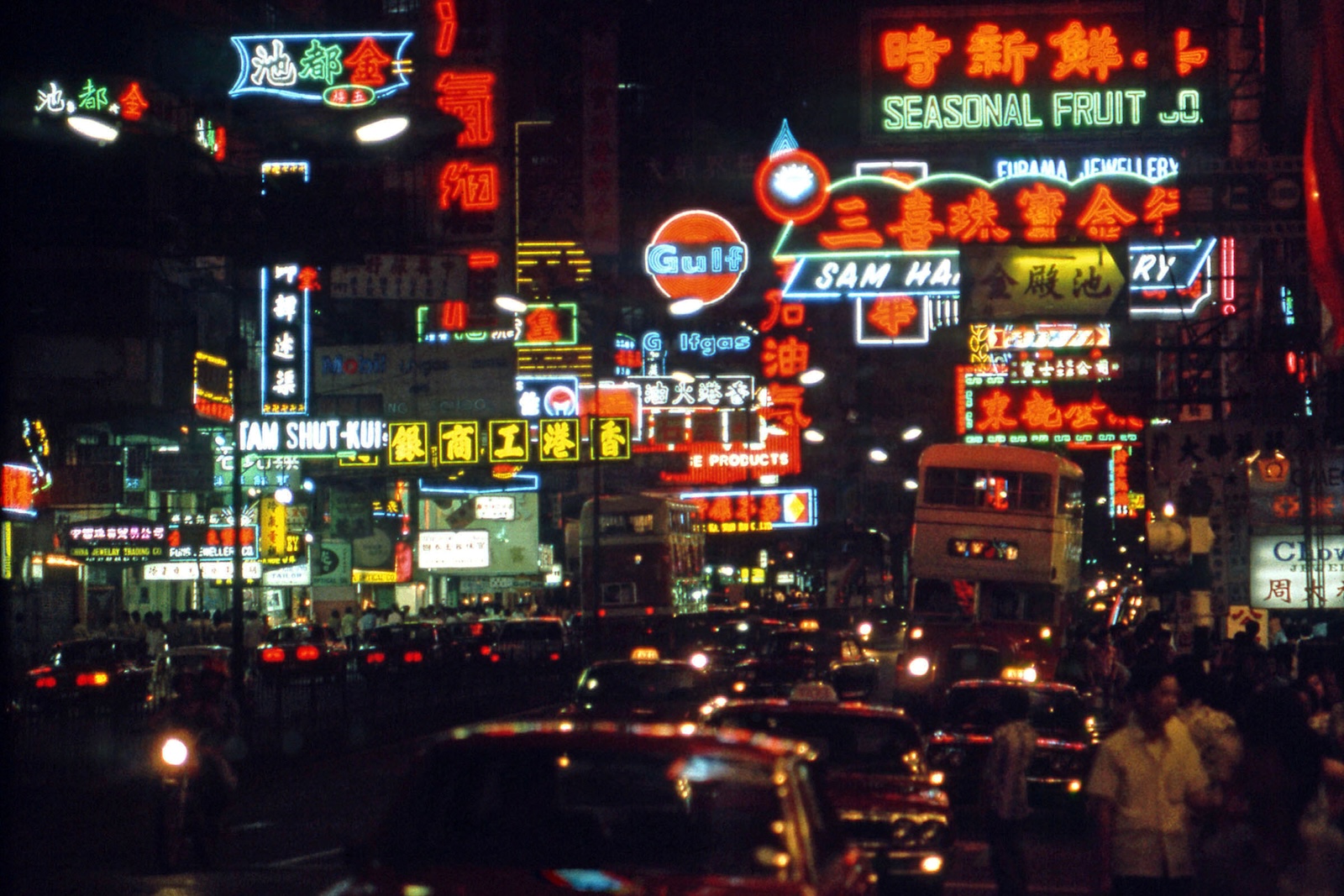Colourful neon lights illuminate a nighttime streetscape in Hong Kong.