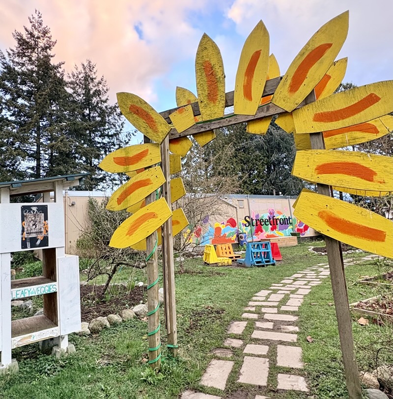 A painted wooden sunflower arbour welcomes visitors to the Grandview Woodland Food Connection garden.