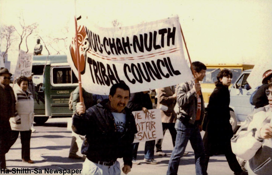 Protesters hold up a sign that says &lsquo;Nuu-chah-nulth Tribal Council&rsquo; and another that says &lsquo;We are not for sale.&rsquo;
