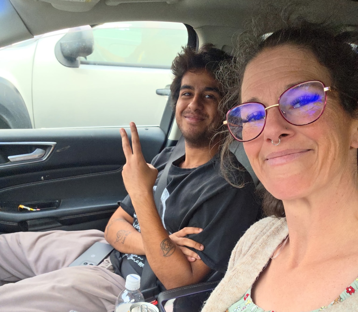 A man and a woman smile for a selfie in a vehicle.