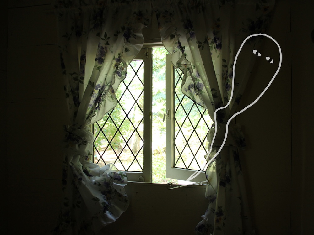 A wisp of ghost emerges from an open leaded window.