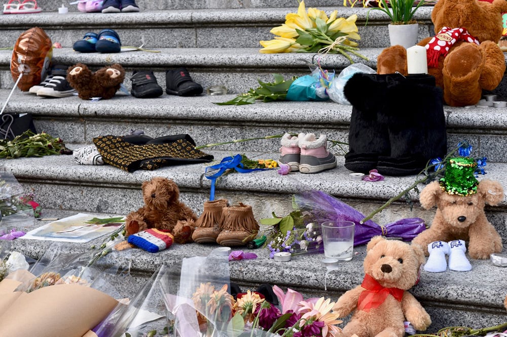 Teddy bears, children’s shoes and flowers on the grey stone steps of the Vancouver Art Gallery.
