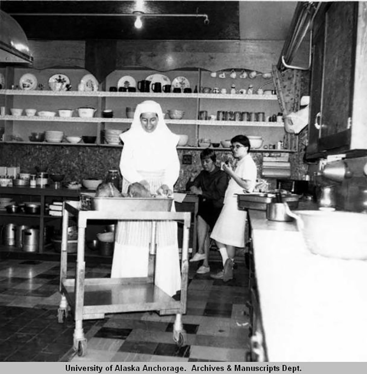 An old, black-and-white photo of Sister Mary Ida Brasseur preparing lunching in 1966 Alaska.