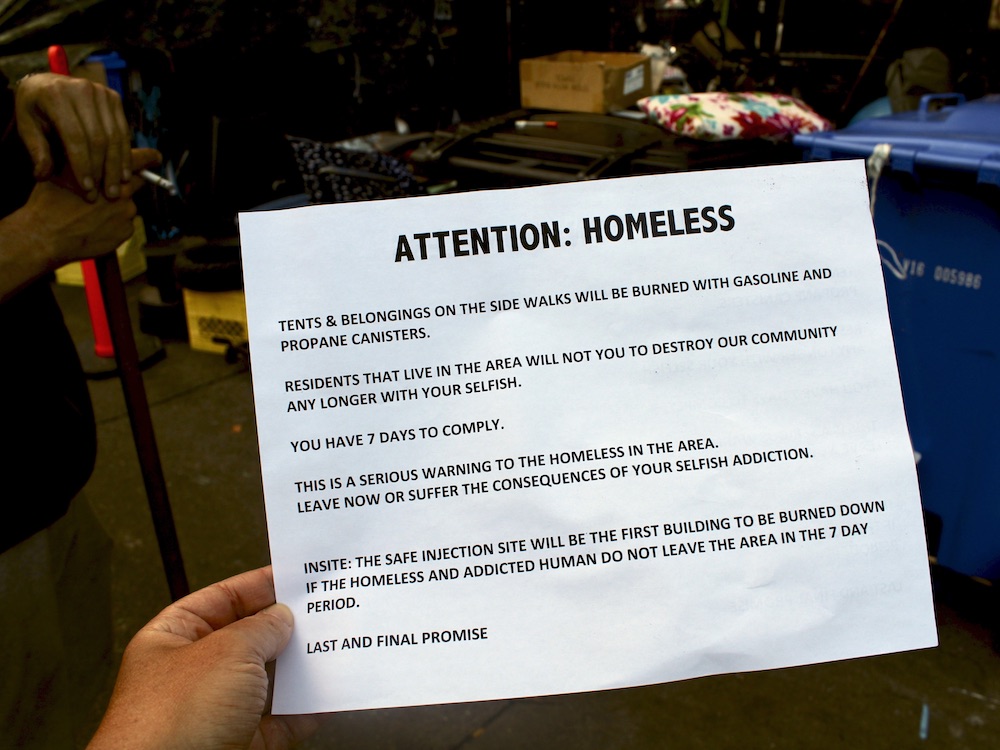 A threatening flyer towards unhoused people tells them to vacate the area.