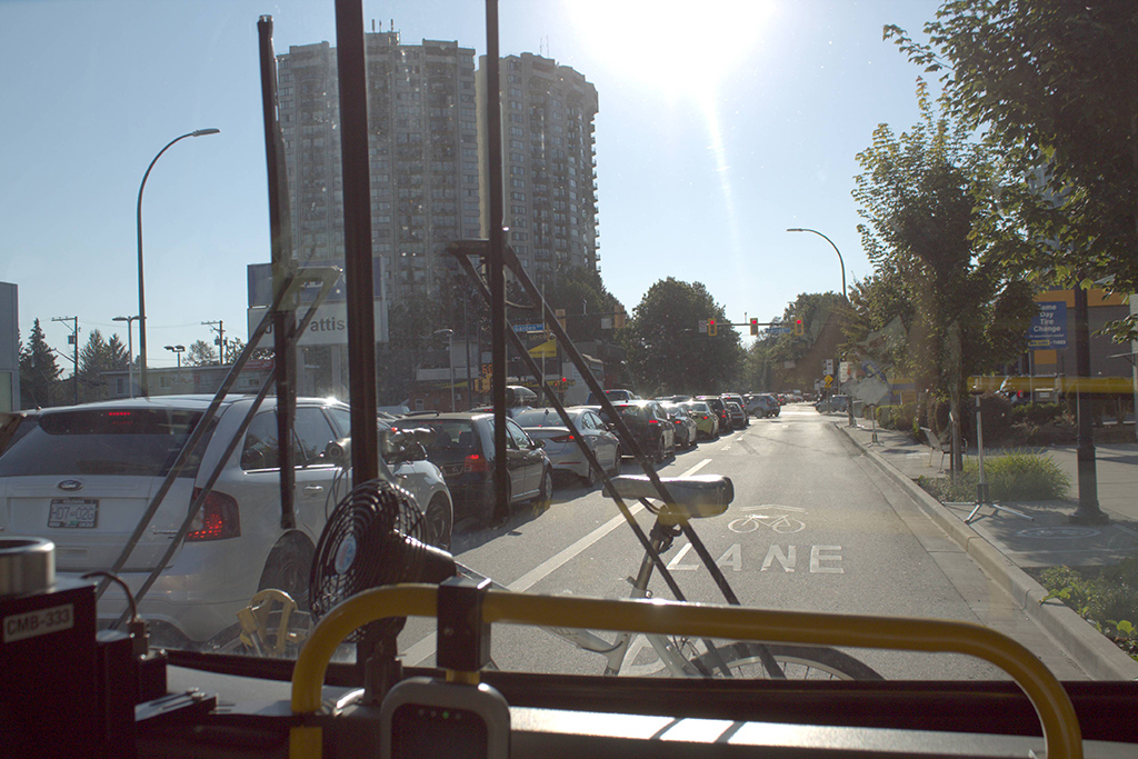 A view out the window of the 255 bus in North Vancouver. Full lanes of traffic to the left of the frame show how busy the route is, even on off hours.