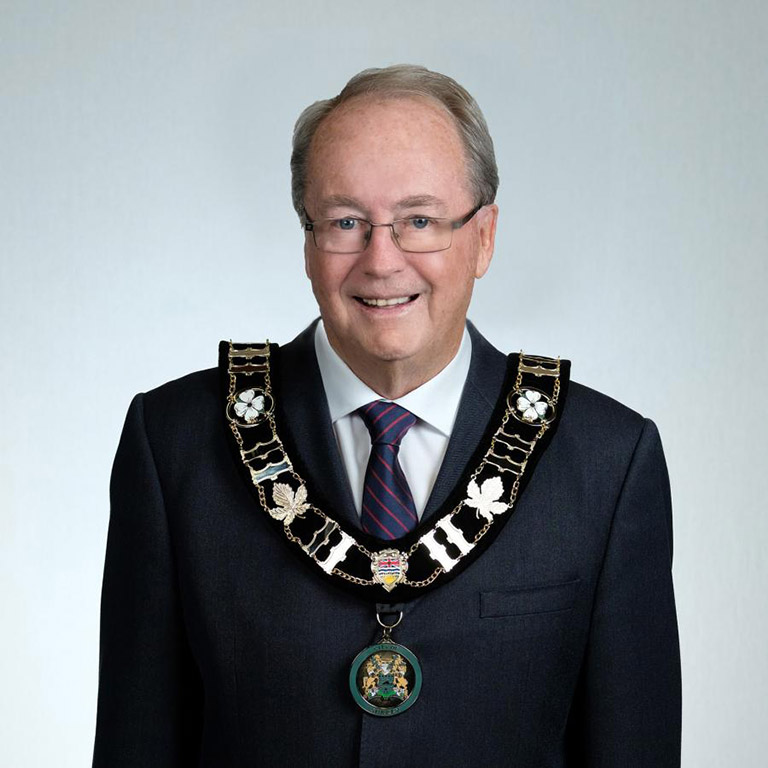 A portrait of a man in his late-70s wearing a suit and the ornate mayoral chain of office.