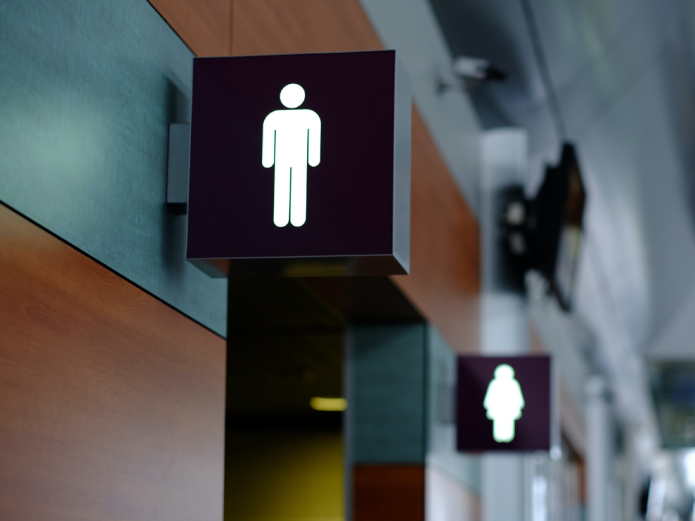 Washroom signs for the men’s room and women’s room are visible in a public location.

