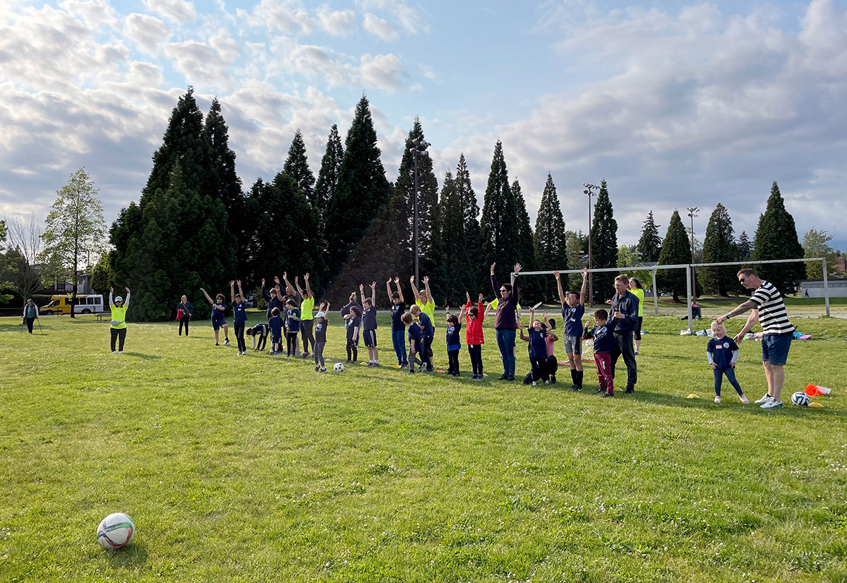 Line of soccer players on field with soccer ball in foreground.