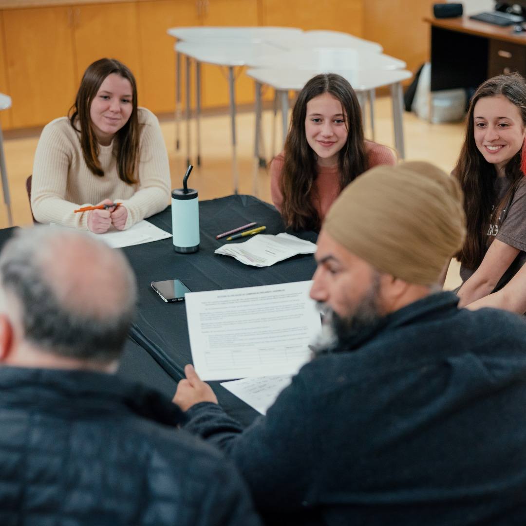 NDP Party Leader Jagmeet Singh and NDP MP for Courtenay–Alberni, Gord Johns, sit around a table with four youth from the Qualicum Beach chapter of Fridays for the Future.